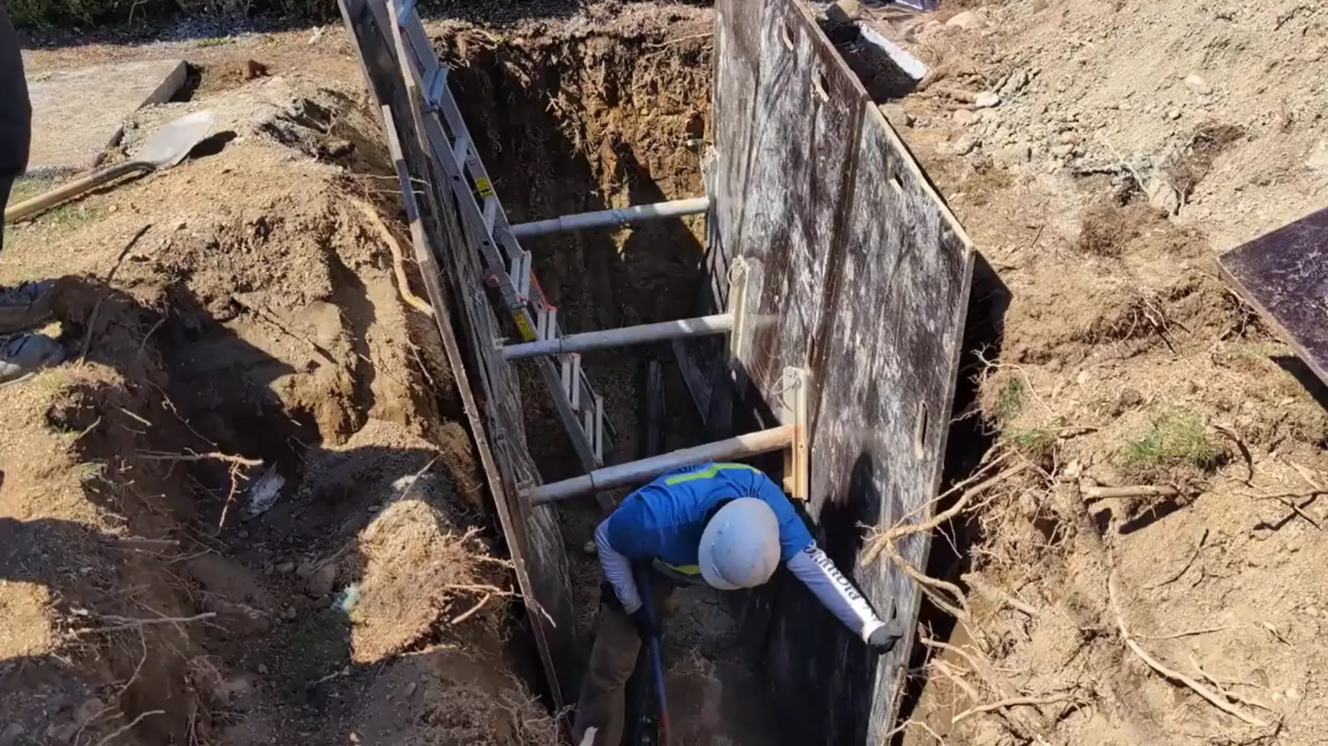 Trenchless access pit with pipe exposed